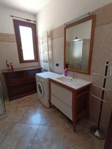 een badkamer met een wasmachine en een wastafel bij Portoselvaggio Villa Martina in Santa Caterina di Nardò