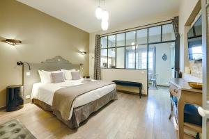 a bedroom with a large bed and a large window at Pelletier du Claux in Carcassonne