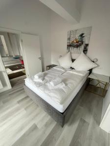 a bedroom with a bed with white sheets and pillows at ROYAL APARTMENTS in Lunca de Sus