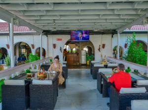 two people sitting at tables in a restaurant at Best Western Jangwani Sea Breeze Resort in Dar es Salaam