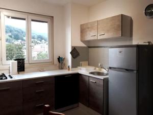 kuchnia z lodówką, zlewem i oknem w obiekcie Bel appartement 6 personnes proche La Bresse w mieście Cornimont
