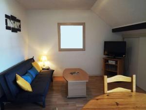 salon z niebieską kanapą i telewizorem w obiekcie Bel appartement 6 personnes proche La Bresse w mieście Cornimont