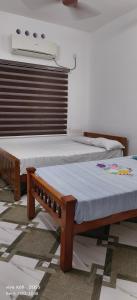 two beds sitting next to each other in a room at Oman house 2.O in Ernakulam