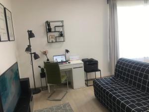 Pokój z biurkiem z komputerem i kanapą w obiekcie Apartment Premium w Pradze