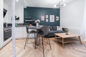 a kitchen and living room with a table and a couch at ⟬Giacomelli⟭ Quartier Calme⁕WIFI⁕Proche Michelin⁕ in Clermont-Ferrand