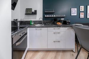a kitchen with white cabinets and a sink at ⟬Giacomelli⟭ Quartier Calme⁕WIFI⁕Proche Michelin⁕ in Clermont-Ferrand