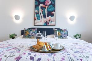 a tray with a croissant and a breakfast on a bed at BOUTIQUE RESIDENCES at GAUDENZDORFER in Vienna