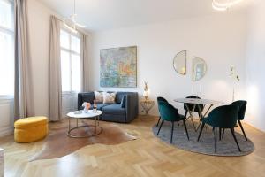 a living room with a couch and a table and chairs at BOUTIQUE RESIDENCES at GAUDENZDORFER in Vienna