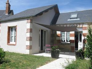 a white house with a pink chair on a patio at maisonette cosy Blois in Blois