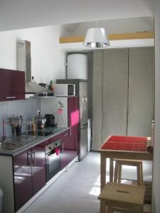 a kitchen with purple cabinets and a table in it at maisonette cosy Blois in Blois