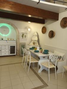a kitchen with a white table and chairs and a counter at TRULLI ALLEGRETTI in Noci