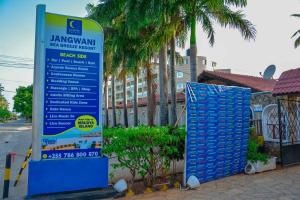 a sign on the side of a street next to a building at Jangwani Sea Breeze Resort in Dar es Salaam