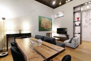 ミラノにあるLa Chambre Milano Guest Houseの木製のテーブルと椅子のあるリビングルーム