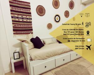 ein Schlafzimmer mit einem Bett und einer Wand mit einem Banner in der Unterkunft Studio le Petit Pantin - Cozy nest in Pantin