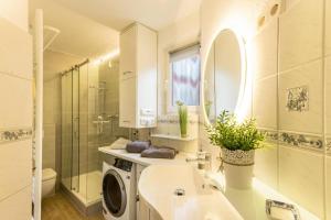 a bathroom with a sink and a washing machine at Am Horumertief in Wangerland +22 photos
