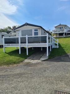 a white house with a porch and a white fence at 107 Arran View with WiFi in Ayr +6 photos