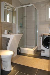 a bathroom with a shower and a toilet and a washing machine at Ferienhaus Refugium in Sessenbach