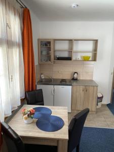 a kitchen with a table with blue cushions on it at Pension Bystřenka in Špindlerův Mlýn