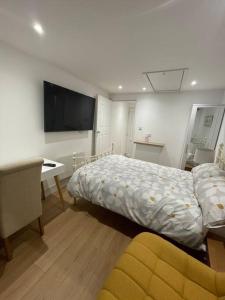 a bedroom with a bed and a desk and a television at 1 bedroom guest suite near city centre. in Gloucester