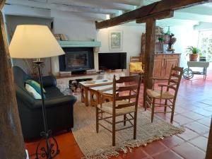 sala de estar con mesa, sillas y chimenea en Gîtes Lalaurie, en Sauveterre-la-Lémance