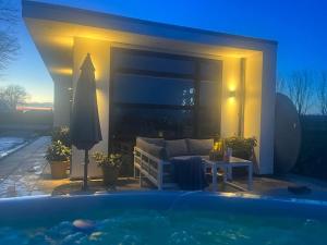 a swimming pool in front of a house with a couch at Luxus Chalet Hafenblick in Lathum