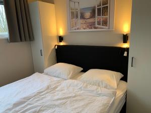 een slaapkamer met een bed met 2 kussens erop bij Luxus Chalet Hafenblick in Lathum