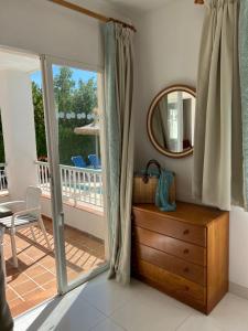 een kamer met een houten dressoir en een spiegel bij Villa Alexia - APARTMENT ISLA - Sunny One Bedroom Apt - Balcony-Terrace in Port de Pollença +49 foto's