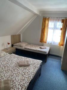 スピンドレルフ・ムリンにあるPension Bystřenkaのベッド2台と窓が備わる客室です。