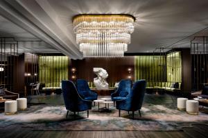 a lobby with chairs and a table and a chandelier at The Gwen, a Luxury Collection Hotel, Michigan Avenue Chicago in Chicago