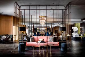 a living room with a pink couch and a chandelier at The Gwen, a Luxury Collection Hotel, Michigan Avenue Chicago in Chicago