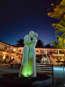 a statue of a woman in a dress at night at Sunbloom Beachfront Hotel and Restaurant in Sinabacan