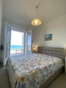 a bedroom with a bed with a view of the ocean at La Porta sul Lungomare in Castelsardo