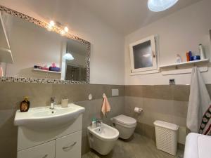 La salle de bains est pourvue d'un lavabo, de toilettes et d'un miroir. dans l'établissement La Porta sul Lungomare, à Castelsardo