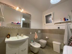 a bathroom with a sink and a toilet and a mirror at La Porta sul Lungomare in Castelsardo +21 photos