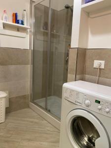 a washing machine in a bathroom with a shower at La Porta sul Lungomare in Castelsardo