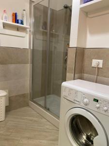 カステルサルドにあるLa Porta sul Lungomareのバスルーム(シャワー付)の洗濯機が備わります。