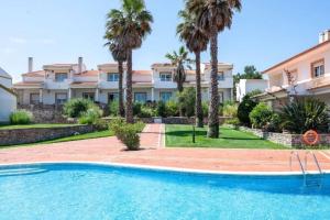 uma villa com piscina e palmeiras em Pool/Golf/Ocean resort home in Amoreira em Amoreira