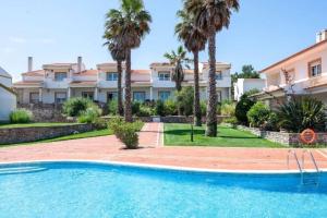 a villa with a swimming pool and palm trees at Pool-Golf-Ocean resort home in Praia Del Rey in Amoreira