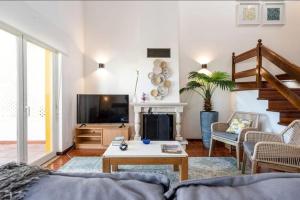 uma sala de estar com um sofá e uma televisão em Pool/Golf/Ocean resort home in Amoreira em Amoreira