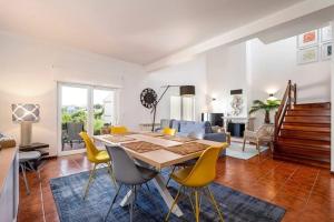 une salle à manger avec une table et des chaises jaunes dans l'établissement Pool/Golf/Ocean resort home in Amoreira, à Amoreira