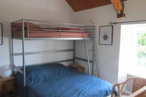 ein Schlafzimmer mit einem Etagenbett in einem Zimmer in der Unterkunft Petite maison entre mer et campagne in Les Pieux