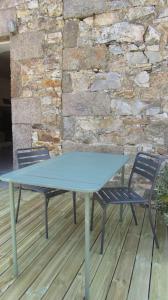 einen blauen Tisch und zwei Stühle auf einer Holzterrasse in der Unterkunft Petite maison entre mer et campagne in Les Pieux
