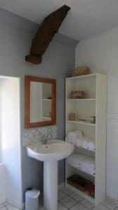 ein Bad mit einem Waschbecken und einem Spiegel in der Unterkunft Petite maison entre mer et campagne in Les Pieux
