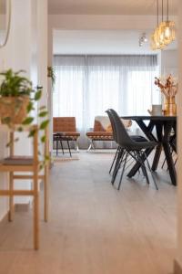 - un salon avec une table à manger et des chaises dans l'établissement Ruime penthouse tot 8 personen vlakbij het centrum, à Ostende