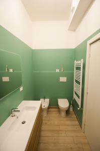 een groene badkamer met een wastafel en een toilet bij vada vacanze in Vada