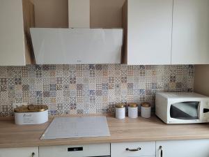 eine Küchentheke mit Mikrowelle und einigen Tassen in der Unterkunft Apartament na Wąskiej in Bydgoszcz