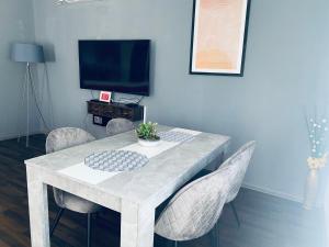 een eettafel met stoelen en een televisie bij Apartment Zvečaj in Ðakovo