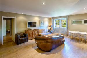 a living room with a leather couch and a table at Pelletier du Claux in Carcassonne