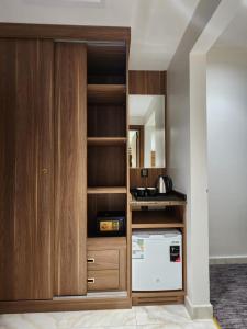 Il comprend une cuisine avec une armoire en bois et un lave-vaisselle. dans l'établissement فندق رواء العزيزية, à La Mecque