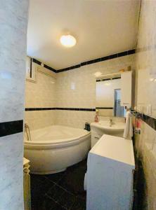 Baño blanco con bañera y lavamanos en Apartment Zvečaj, en Ðakovo